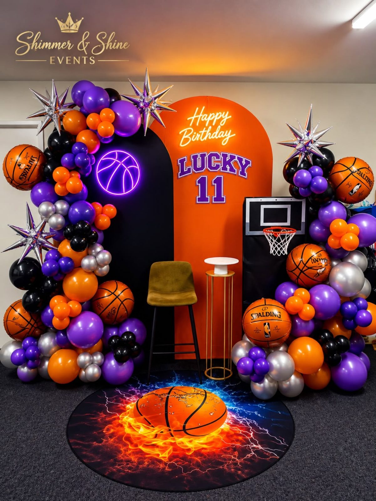 Orange and purple basketball-themed balloon garland with a neon Happy Birthday sign and lit basketball hoop